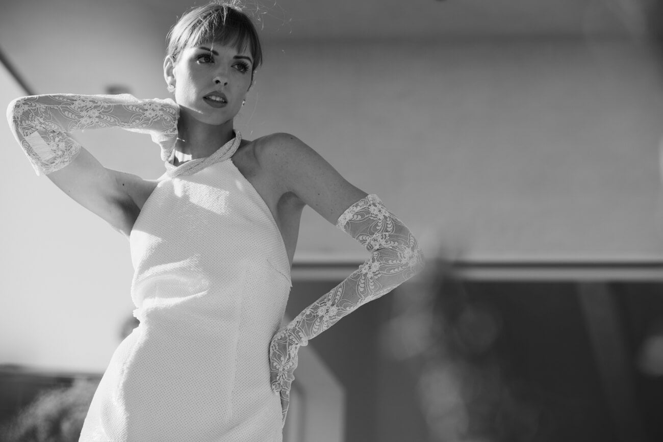 Modern bridal gown with lace sleeves and halter neckline, black and white fashion photo