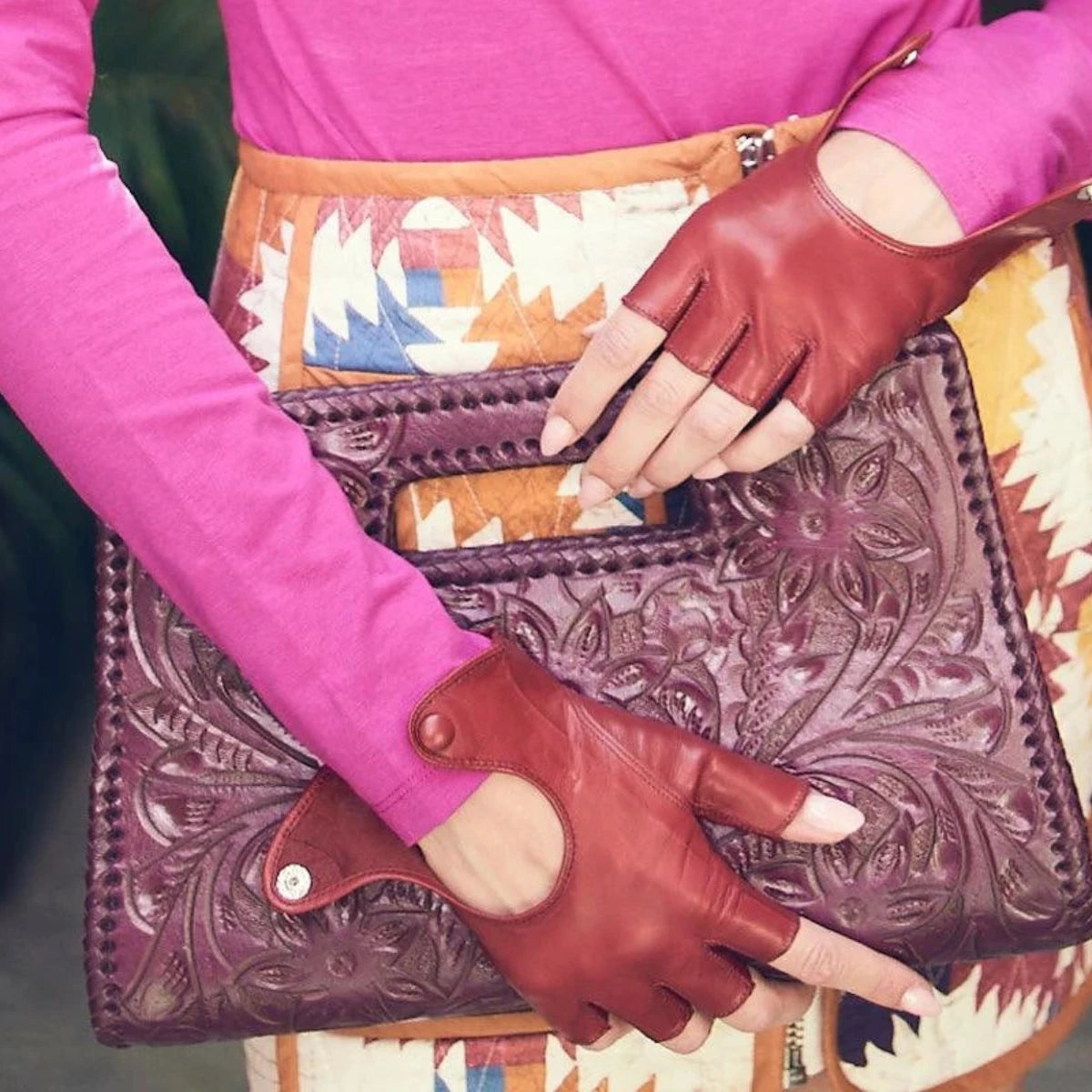 Brown leather fingerless gloves with pink sleeves and tooled leather clutch