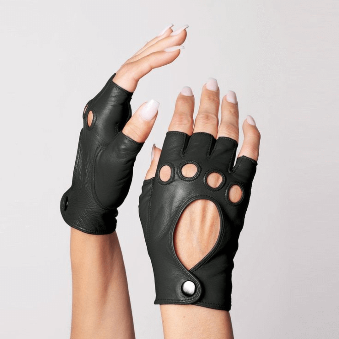 Hand modeling Patricia Field's Paris Black Italian leather fingerless driving gloves from Emily in Paris with snap button closure, showing perfect fit.