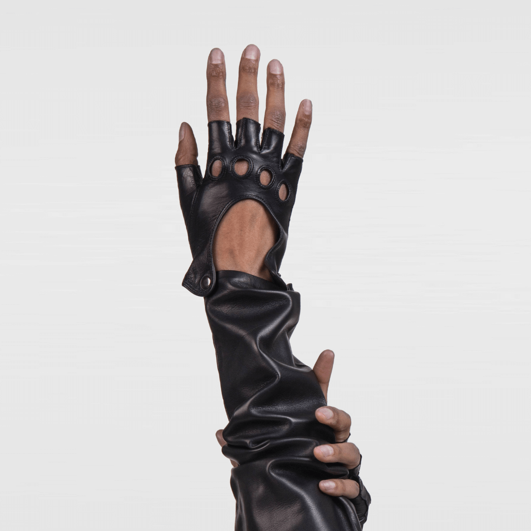 Hand modeling Patricia Field's Italian leather fingerless driving gloves from Emily in Paris with snap button closure, showing perfect fit with full sleeve styling.