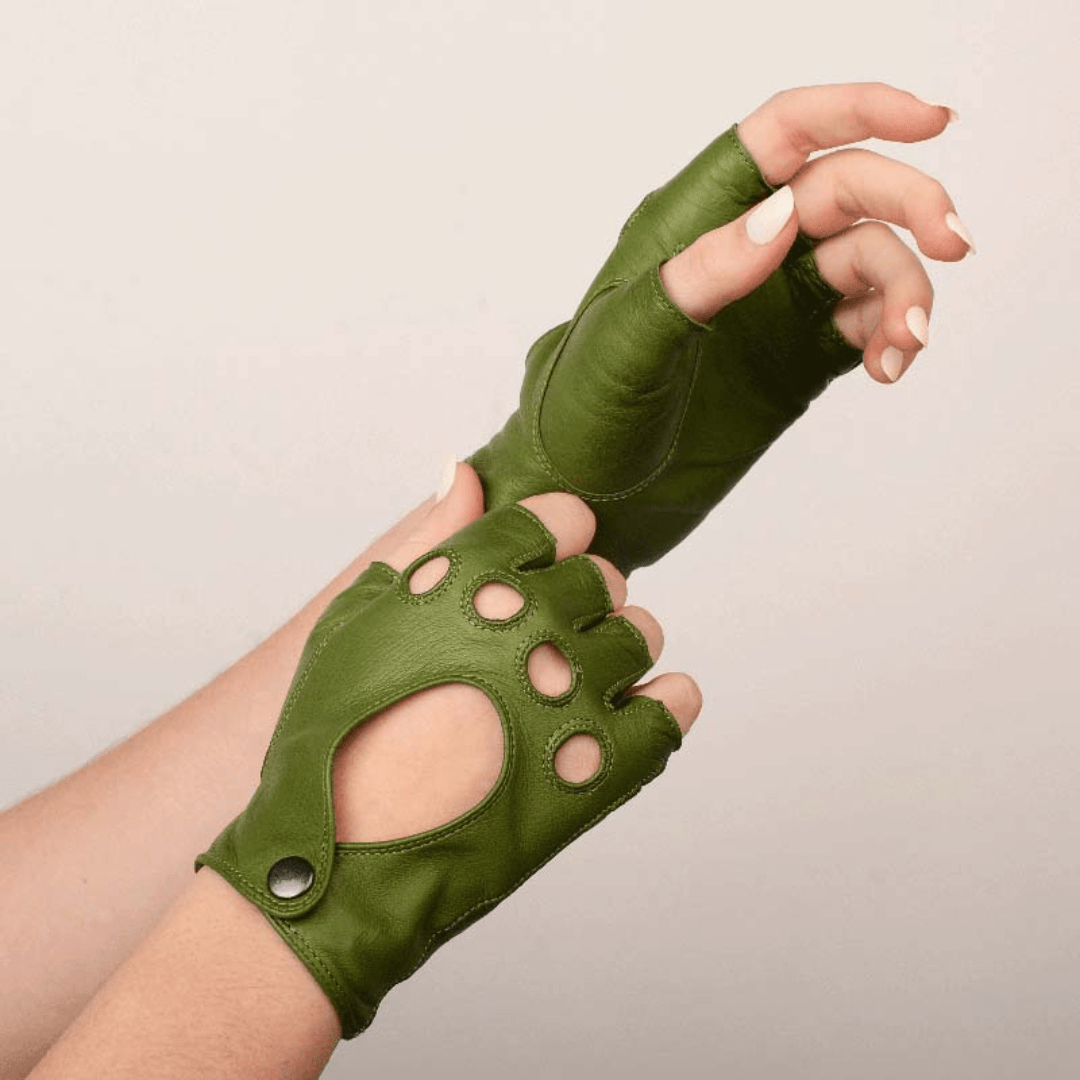 Hand modeling Patricia Field's Central Park Green Italian leather fingerless driving gloves from Emily in Paris with snap button closure.