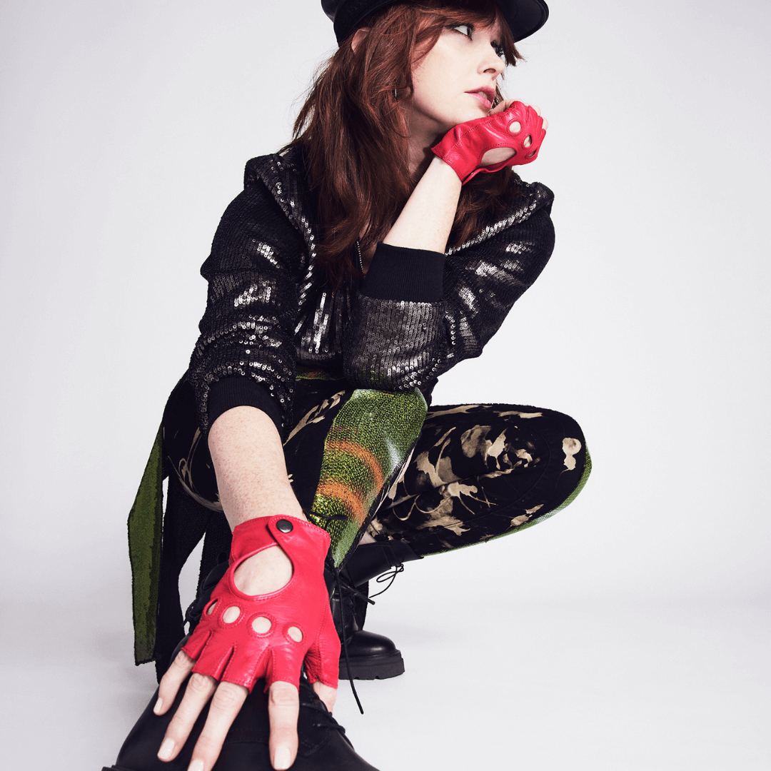 Model wearing Patricia Field's Hot Stuff Pink Italian leather fingerless driving gloves from Emily in Paris with snap button closure, showcasing the design.