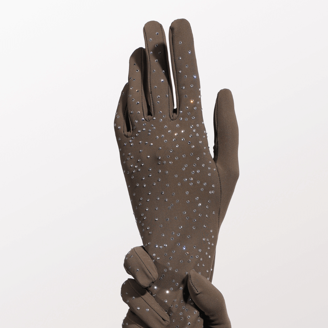 Close-up of a single olive green glove adorned with sparkling crystals, displayed against a white background with a second glove gently holding the wrist.