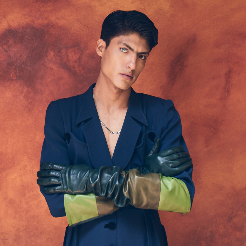 Two-tone leather opera gloves with navy blazer against terracotta backdrop