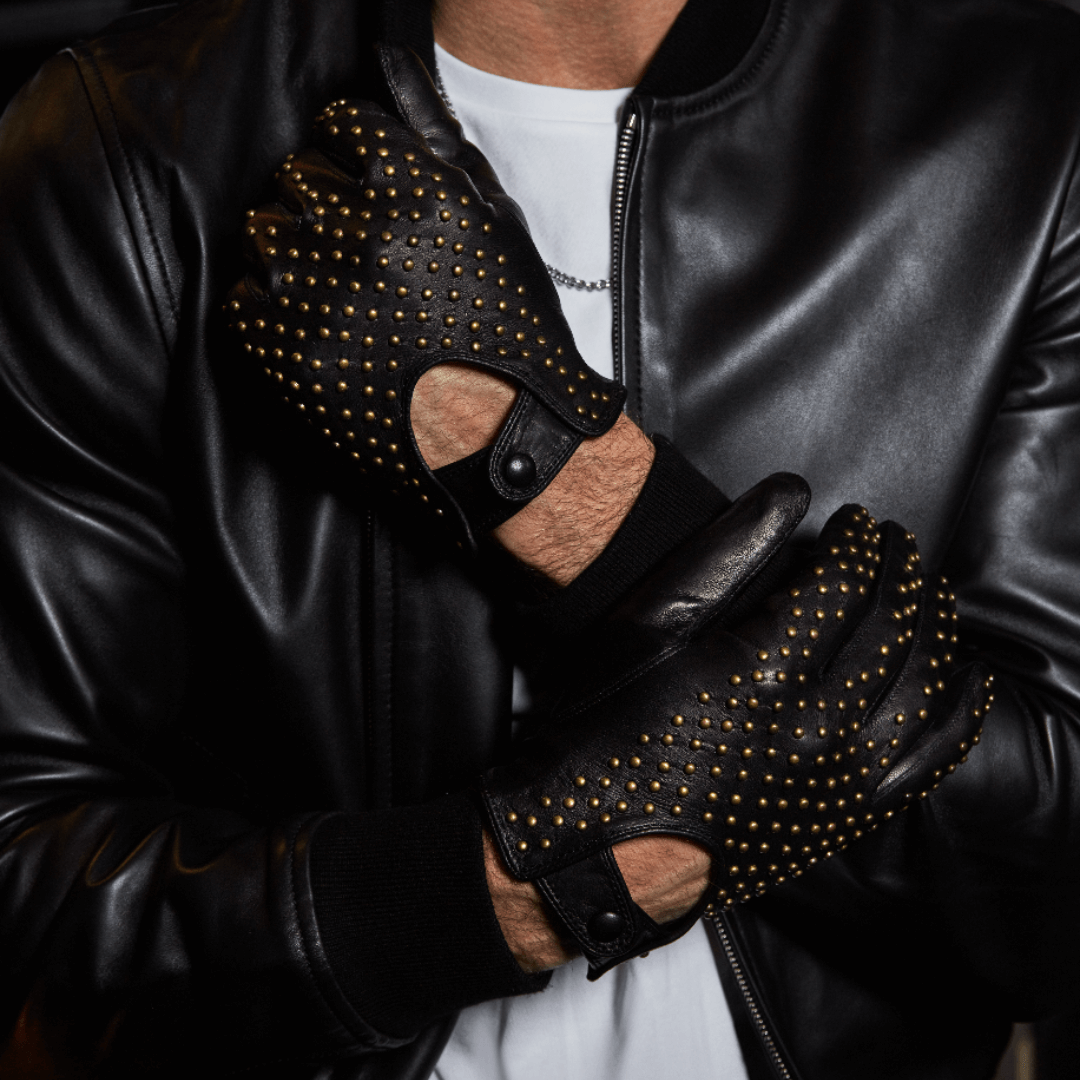 model wearing men's black studded leather driving gloves against white tshirt and black leather jacket