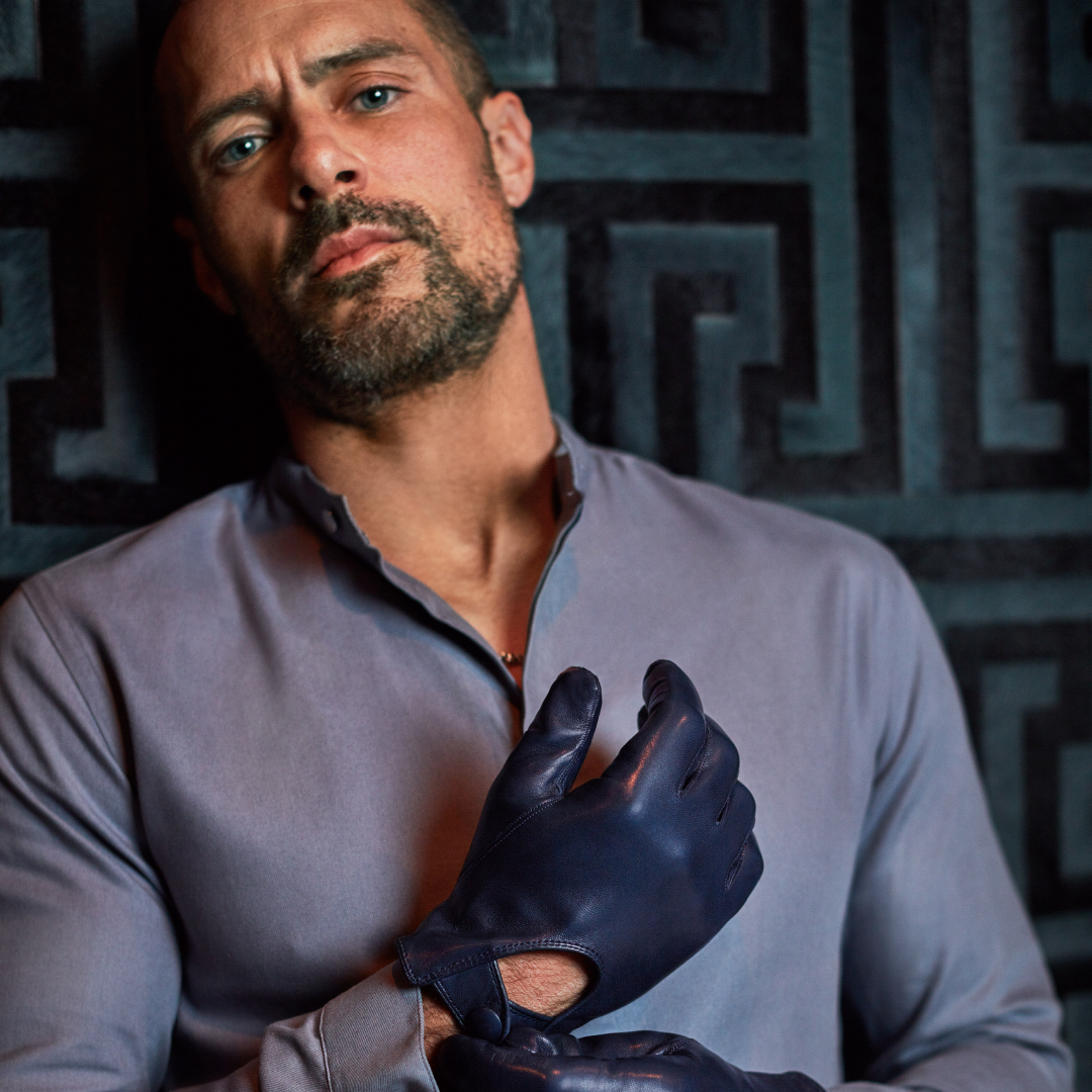 model wearing Navy leather driving gloves with grey shirt, luxury menswear portrait