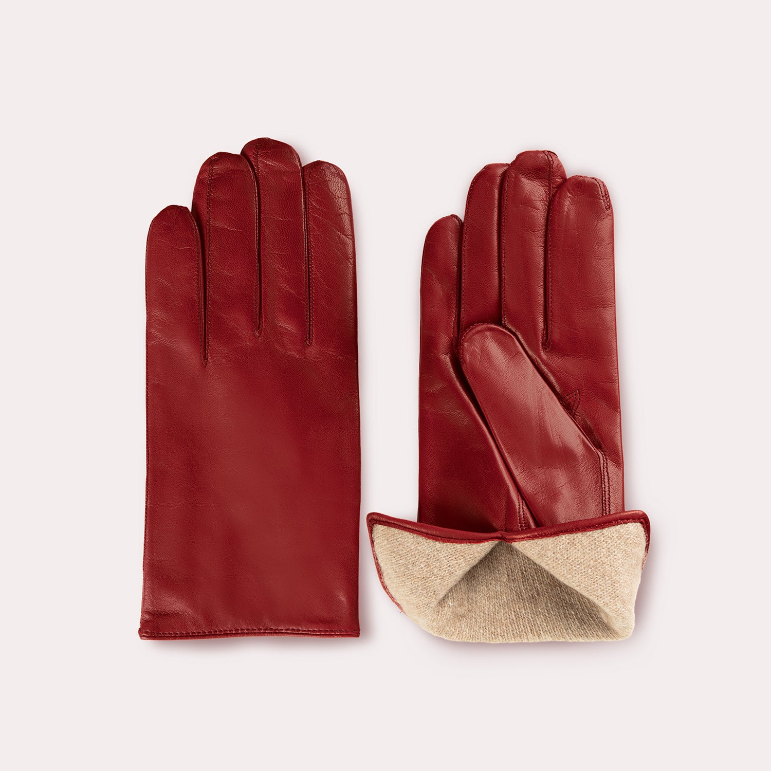 Red leather gloves with beige fold-over cuff, product flatlay