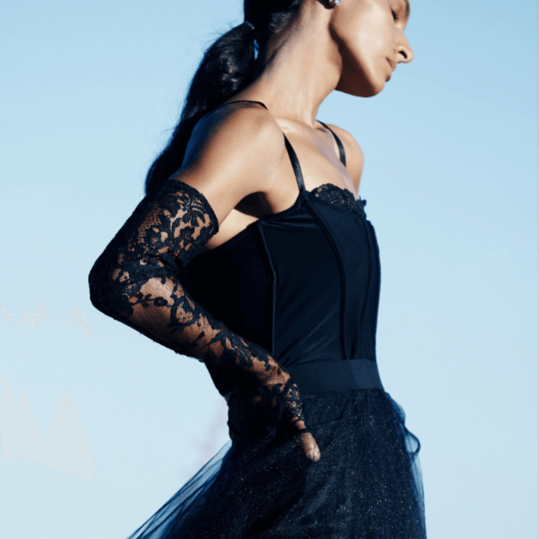 Black evening gown with lace sleeves and tulle skirt against blue sky
